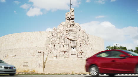 The-Mayan-style-homeland-monument-in-Merida,-Yucatan-with-traffic-going-past-on-a-sunny-day