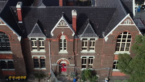 Drone-ascend-and-reveal-old-church-turned-into-a-school-with-active-renovations-and-maintenance