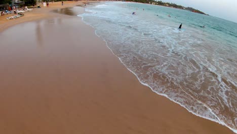 Vuelo-Aéreo-Sobre-La-Playa-En-Mirissa-Al-Atardecer,-Turistas-Divirtiéndose,-Sri-Lanka