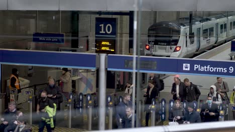 Passagiere,-Die-Nach-Der-Ankunft-Aus-Dem-Zug-Am-Bahnhof-Kings-Cross-Die-Ticketschranken-Verlassen