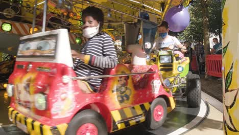 happy-excited-kids-riding-in-colorful-toy-vehicles-on-amusement-park