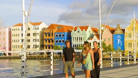 Tourists-walking-and-taking-photos-on-the-Queen-Emma-Bridge-over-Saint-Ann-Bay-in-the-vibrant-and-colorful-district-of-Punda-in-Willemstad,-on-the-Caribbean-island-of-Curacao