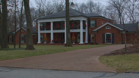 Shot-from-right-to-left-of-Fortuna-Missouri-homestead-beautifully-decorated-with-red-bows-and-Christmas-trees-in-rural-Missouri,-USA-during-a-cloudy-day