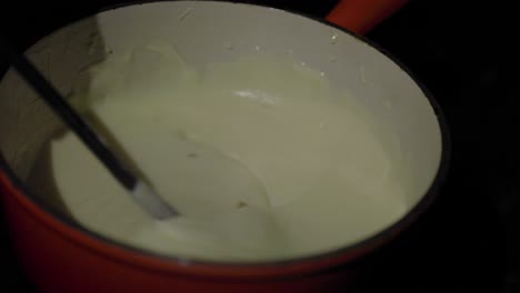 Slow-motion-close-up,-dipping-bread-into-fondue-bowl-full-of-cheese