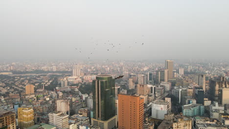 Paisaje-Urbano-Aéreo-Con-Pájaros-Dando-Vueltas-Por-Encima-De-Los-Edificios-En-Dhaka