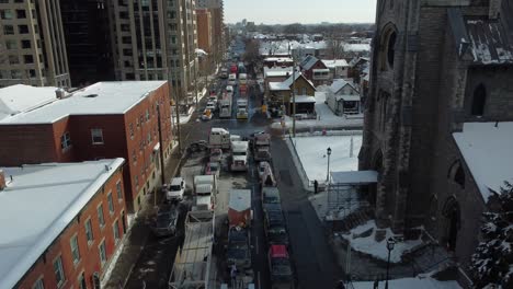 Drone-Shot-of-Lots-of-Protesting-Freedom-Convoy-Truckers-at-Standstill-on-Nepean-Street-in-Downtown-Ottawa-City,-Canada