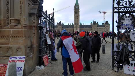 Protestantes-Formándose-Frente-A-Un-Edificio-Del-Gobierno-Con-Pancartas-Y-Banderas-Canadienses-En-Ottawa