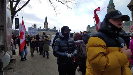 Demonstranten-In-Masken-Marschieren-In-Der-Nähe-Des-Parlamentshügels-Mit-Kanadischen-Flaggen-Und-Plakaten