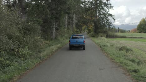 Camioneta-Ram-Azul-Conduciendo-A-Lo-Largo-De-Un-Camino-Rural
