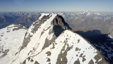 Enorme-Montaña-Con-Roca-Y-Nieve-En-La-Cima-Entre-Una-Espectacular-Cadena-Montañosa-Muy-Por-Encima-De-Los-Valles-En-Nueva-Zelanda-Durante-El-Amanecer