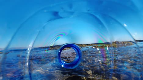 Plastic-bottle-polluting-the-ocean-as-it-drifts-in-the-tidal-waves---as-seen-from-inside-the-bottle