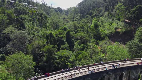 People-Exploring-Nine-Arches-Railway-Bridge,-Demodara,-Sri-Lanka,-Overtake-Low-Shot
