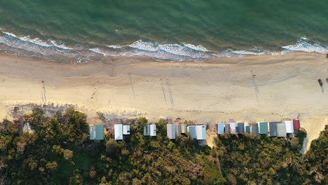 Smooth-aerial-pass-over-Mornington-beach-showing-summer-beach-boxes-at-dusk