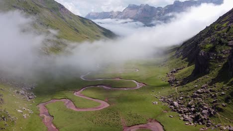 Aguas-Tuertas,-Spanish-Pyrenees,-Spain---Aerial-Drone-View-of-the-Green-Valley,-Curved-River,-Mountains-and-Moving-Clouds