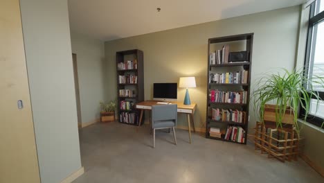 Oficina-Con-Estantes-De-Libros-En-Un-Moderno-Edificio-De-Condominios-Con-Escritorio-Y-Silla