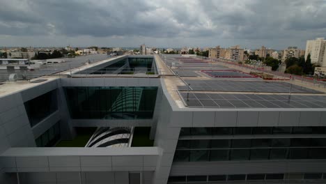 Aerial-view-of-building-with-solar-panels-on-the-roof,-shopping-mall-Azrieli-mall-in-Acre-city-in-Israel