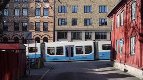 Street-with-tram-and-car-passing-near-Stigbergstorget,-Gothenburg,-Sweden-in-Majorna-Linné-district