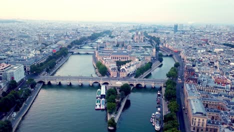 Drone-flying-Seine-river-towards-Ile-de-la-Cite-with-Pont-Neuf-bridge-in-foreground