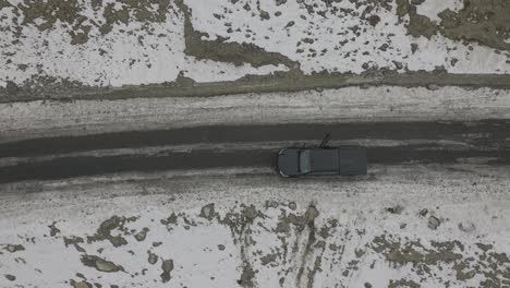 Aerial-Birds-Eye-View-Of-People-Getting-Inside-Black-Truck-Parked-In-Snowy-Roadside-Landscape