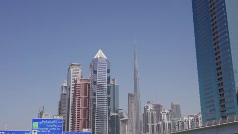 Burj-Khalifa-Y-Rascacielos-Y-Torres-Del-Centro-De-Dubai,-Vista-Desde-La-Autopista-Y-El-Vehículo-En-Movimiento
