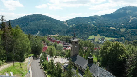 Aerial-drone-view-of-Sanctuary-of-Mother-of-God,-Polish-Queen-and-Beskid-mountains-in-the-background
