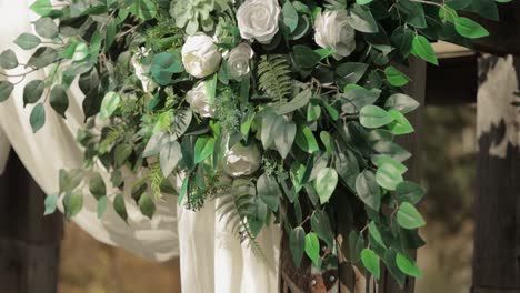 Beautiful-white-rose-floral-arrangement-mounted-on-a-rustic-wedding-arch-at-a-wedding-ceremony-at-Bean-Town-Ranch