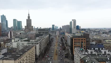 Aerial-view-of-traffic-on-the-Marszałkowska-street-in-cloudy-Warsaw,-spring-in-Poland---reverse,-drone-shot