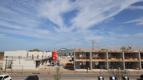 Day-passing-moving-time-lapse-of-work-being-done-at-real-estate-project-PUUR21-housing-construction-site-urban-development-plan-Noorderhaven-neighbourhood-against-a-blue-sky-with-cloud-formation
