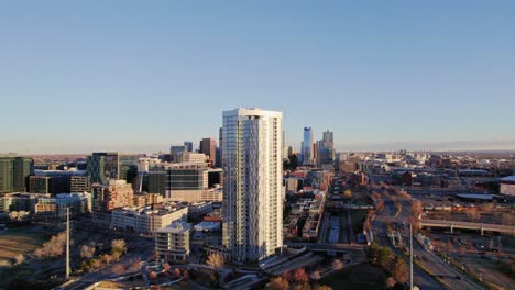 Drone-Aerial-View-Of-The-Confluence-Modern-Apartment-Complex-High-Rise-Building-And-Denver-City-Skyline-During-Golden-Hour-Sunset