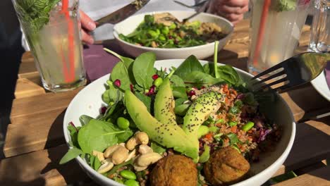 Eating-fresh-falafel-bowl-with-salad-and-avocado