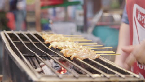 Street-Food-Vendor-grilling-Satay-Chicken-Skewers-on-Charcoal-Grill-in-the-Streets-of-Bangkok,-Famous-Street-Food