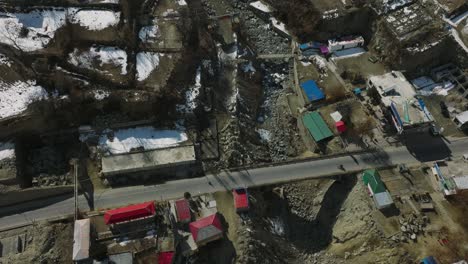 Drohne-Fliegt-über-Der-Brücke-über-Dem-Trockenen-Flussbett-In-Der-Dorfstadt-Im-Hunza-tal