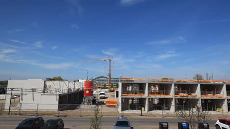 Time-lapse-of-work-being-done-at-real-estate-project-PUUR21-new-housing-construction-site-urban-development-plan-Noorderhaven-neighbourhood-against-a-blue-sky-with-cloud-formation-coming-in