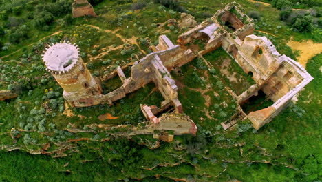 Aerial-bird's-eye-shot-over-the-ruins-of-an-old-building-on-the-hill-top-surrounded-by-green-vegetation-in-north-of-Troina,-Sicily,-Italy-at-daytime