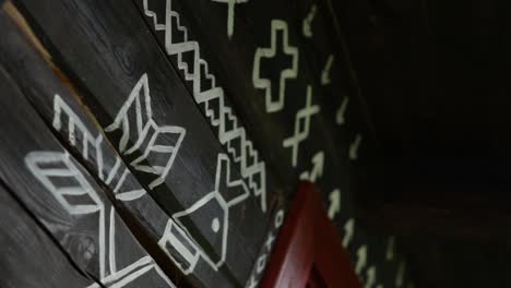 Close-up-angled-moving-shot-of-ornamental-traditional-Slovakian-symbols-are-painted-on-a-wooden-rural-village-house-in-Čičmany,-Slovakia,-worlds-cultural-heritage,-a-famous-landmark-in-central-Europe