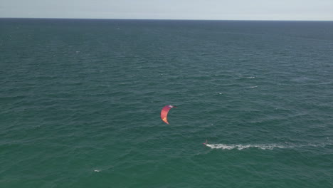 Aerial:-Kite-surfer-speeds-downwind-quickly-on-empty-expanse-of-ocean