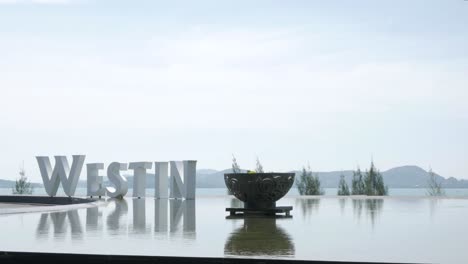 Westin-Siray-Bay-Hotel-sign-with-background-of-summer-sea-and-mountain-range-in-Phuket