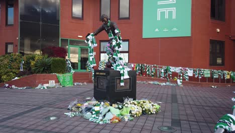 Wide-shot-of-the-statue-of-Jimmy-Johnstone-covered-with-scarves-and-flowers
