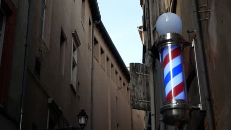 A-traditional-spinning-barbershop-pole-on-a-city-streetcorner-at-dusk---isolated