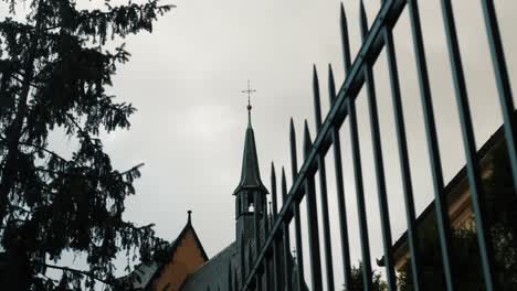 Old-church-with-piked-fence-in-front-and-trees