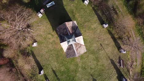 Drone-Shot-of-a-Chapel-surrounded-by-Tombstones-on-top-of-a-Hill
