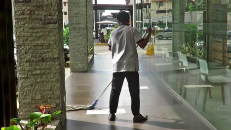 A-janitor-gets-busy-tidying-up-and-polishing-a-hallway-around-a-commercial-establishment-in-typhoon-hit-Cebu-City,-Philippines