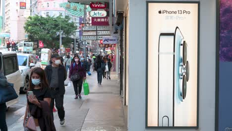 Pedestrians-wearing-face-masks-walk-past-an-American-multinational-technology-company-Apple-Iphone-13-Pro-smartphone-advertisement-in-Hong-Kong