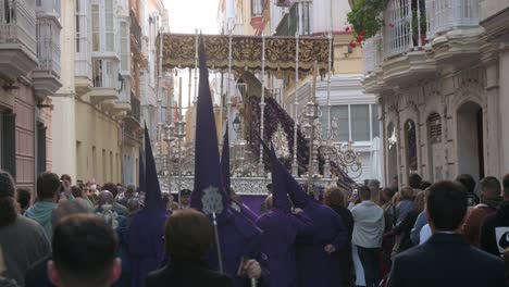 Penitents-carry-the-image-of-Jesus-Christ-during-a-procession-as-they-celebrate-Holy-Week-in-Cadiz,-Spain