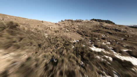 Volando-Sobre-árboles-Y-Arbustos-En-Un-Paisaje-Montañoso-Cubierto-De-Nieve-Con-Un-Dron-Fpv