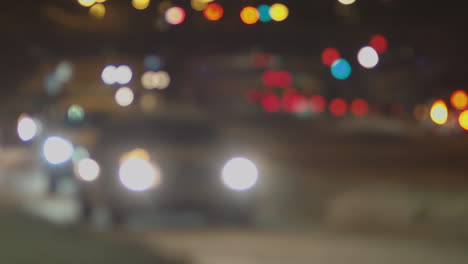 Defocused-traffic-drives-past-street-level-camera-at-night