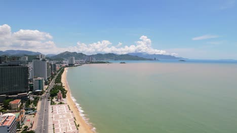 high-altitude-view-of-the-coastal-road-along-the-white-sand-beach-of-Nha-Trang-Vietnam-overlooking-the-turquoise-green-ocean-sea-on-a-bright-sunny-day