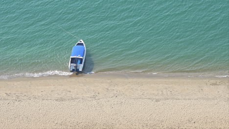 Rule-of-Thirds,-High-angle-of-a-lone-boat-moored-along-the-sandy-shoreline