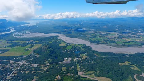 Airplane-flight-east-of-Palmer-Alaska-with-the-town,-Matanuska-River-and-Palmer-Airport-in-the-distance