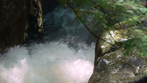Close-up-of-the-spray-of-a-forest-waterfall-in-slow-motion